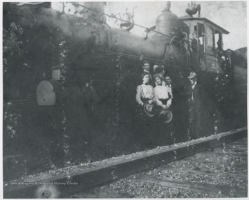 Tall man pictured next to the train is R.O. Murrell. Other subjects unidentified. 