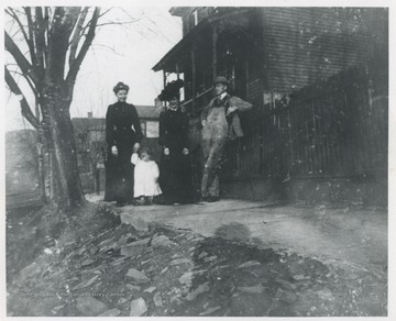 The group is pictured at the corner of Summers Street & 5th Avenue. The woman in the middle is Mrs. R.O. Murrell. Woman on the left is unidentified. 