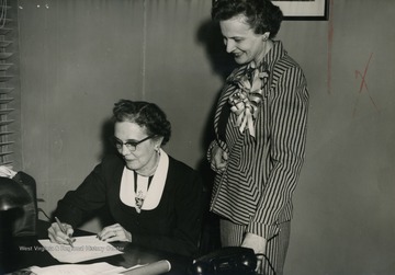 Caption on back of photograph reads: "Picture taken at Weston as Mrs. Davis signs oath of office as only woman member of State Advisory Board Department of Public Assistance. After Mrs. Rush Holt, Secretary of State, administered the oath."