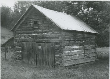 The log cabin is located across a "hard road and bridge" from Blaker's Mill, according to the caption on the back of the photograph. Today, the old cabin is used as a barn.