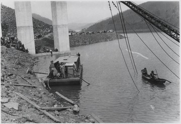 Workers make their way out into the water to repair the damage.Five workmen killed and four injured when the 300-ton span buckled and folded downward into the river. A week after the collapse the men began dismantling the twisted span, using a never before used technique by burning the steel beams with chemicals.