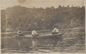 Three unidentified men pictured in a canoe. 