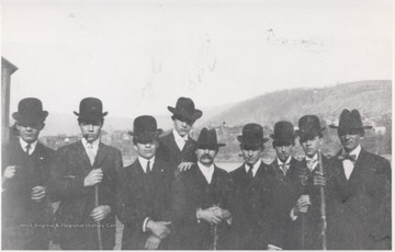 A group of men pose together at the ceremony. Third from left is Herald Eagle. The city is pictured in the background.