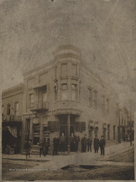 A group of men are pictured outside the building. Subjects unidentified. There appears to be construction underway on the street in front of the bank. 