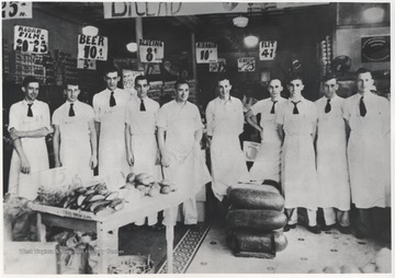 A group of grocer employees pose inside the first ever Kroger inside of Hinton, located on 3rd Avenue. Later, this store turned into the Bowlings Dairy Bar. Subjects unidentified.
