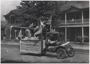 The Hinton Construction Co. parade float advances down Temple Street. The sign on the side of the vehicle reads, "We believe in preparedness, and are prepared to build houses and do general contract work on short notice."