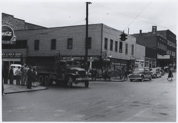 A truck carrying uniformed soldiers is pictured at the intersection of Ballengee Street and 2nd Avenue. Subjects unidentified. 