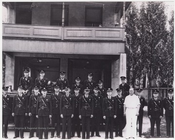 Fire fighters pose together in front of the department building. Subjects unidentified. 