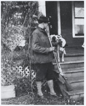 Murrell holds a rifle next to his pets outside of the Flanagan-Murrell home located on the corner of 5th Avenue and Summers Street. 