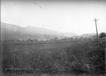 View of a farmer's field and roofs of Franklin, W. Va. in the distance