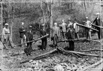 Men work on a rail fence in a rural scene likely in West Virginia