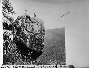 Two boys are pictured on top of the rock, looking east. Subjects unidentified. 