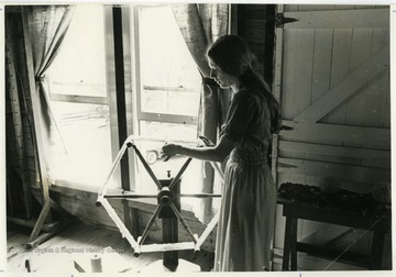 Mary Beth Lind spins at a spinning wheel on the second floor of the Old Mill crafts shop in Harman, West Virginia.The photos in this collection were used in chapters that appeared in Mountain Trace, a publication of Parkersburg High School in West Virginia, edited by Kenneth G. Gilbert.