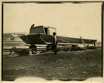 This image is part of the Thompson Family of Canaan Valley Collection. The Thompson family played a large role in the timber industry of Tucker COunty during the 1800s, and later prospered in the region as farmers, business owners, and prominent members of the Canaan Valley community.The image shows two men working on a canal boat in Cumberland, Md.