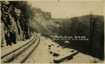A snowy view of Hendricks Grade on the W.M.R.R. with Point Lookout in the distance.This image is part of the Thompson Family of Canaan Valley Collection. The Thompson family played a large role in the timber industry of Tucker County during the 1800s, and later prospered in the region as farmers, business owners, and prominent members of the Canaan Valley community.