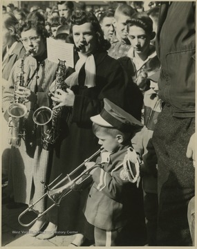 Band members play to celebrate the East Bank High School basketball team winning its first ever state championship title. Young Clinton Jeffreys, mascot for the East Bank High School band, blows a horn to celebrate the homecoming of the State Basktball Champions.