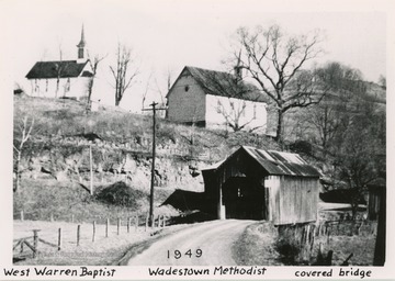 The two churches of different denominations stand next to each other on a hill above a covered bridge. West Warren Baptist is on the left, Wadestown Methodist is in the middle, and in the lower right of the image is the covered bridge.
