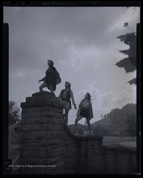 Three unidentified girls pose on top of the stone fence. 