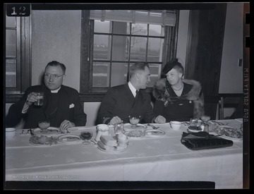 Mrs. Roosevelt, right, dines with two unidentified men during her visit to Jackson's Mill. 