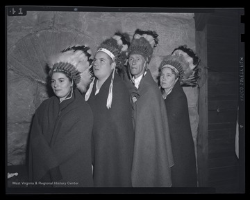 A group of unidentified individuals pose in their Native American costumes. 