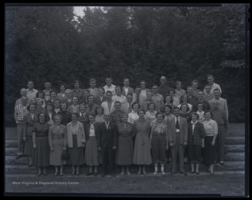 A group of men and women pose together for a group photo. 