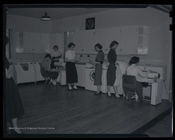 A group of young women study machinery and take notes. Subjects unidentified. 