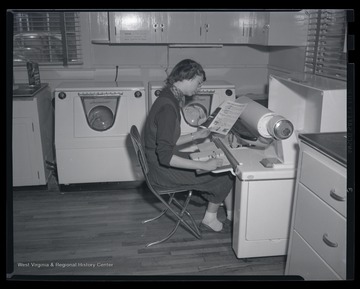 An unidentified woman studies the machinery in front of her. 