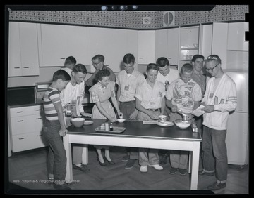 A group of unidentified boys participate in kitchen activities. 