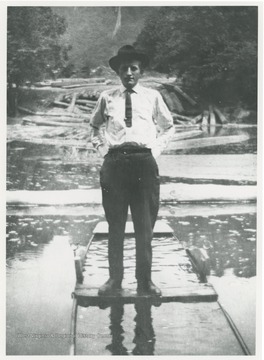 Portrait of a man standing in a flooded boat, possibly the photographer, Robert Keller.