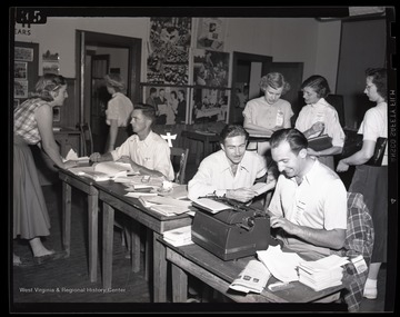 A group of young men and women working. Subjects unidentified. 