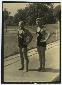 Two unidentified boys are dressed int heir lifeguard swimsuits. 