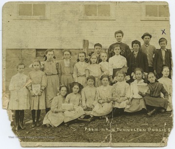 The students of classroom no. 4 pose together for a class photo outside of the school building. C. Paul Miller is marked on the photo with an "x" above his head. 