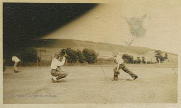 Two boys practice catching and throwing on the baseball field. Subjects unidentified. 