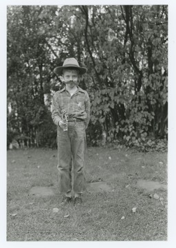 Miller Murrell dressed as sheriff or police officer with false mustache, badge, and toy gun. Location near Hinton, W. Va.