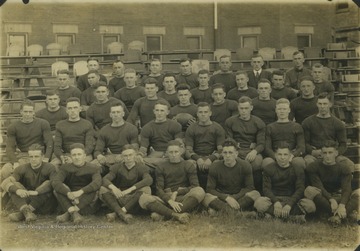 The football players pose together for a team photo.In the back row, from left to right, is unidentified; unidentified Coach Tobin; unidentified;  Coach McIntyre; Manager Sherr; and unidentified.In the fourth row, from left to right is unidentified; player Brooks, Fred Mills ('20); unidentified; unidentified; unidentified; quarterback Charles L. Lewis ('20); and pplayer Webster.In the third row, from left to right, is unidentified; tackle Joseph V. Harrick ('21); guard John B. McCue ('21); Captain Russell Bailey holding the ball('19); player Harris; unidentified; and halfback Andrew 'Rip King.In the second row is guard Russel D. Meredith ('21); player Curry; unidentified; tackle Frank Ice ('18); unidentified; unidentified; player Wagner; unidentified.In the front row from left to right is player Rhodes; halfback J. Howard Lentz ('20); unidentified; unidentified; unidentified; unidentified; unidentified. 