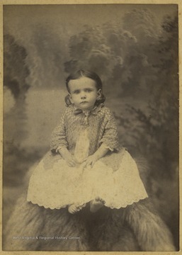Morton is pictured sitting in A. M. Slusher's photo studio. 