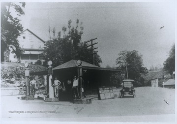 Sam Japser, right, and his associate Ty Cobb, center, stand beside gasoline pumps. 