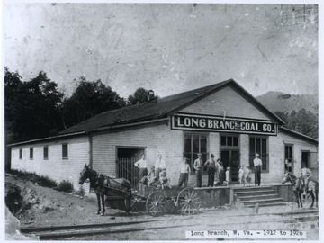 A group of men and children are pictured next to the store entrance. 