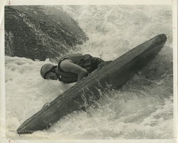 An unidentified man guides his canoe through Calamity Rock at Cheat River Narrows during the National Wildwater Races.