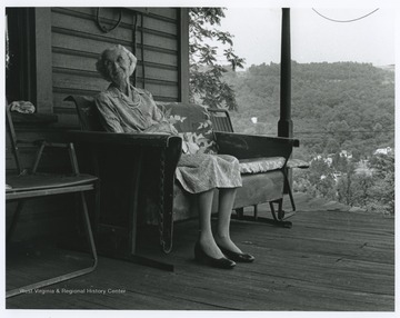 Albright is pictured sitting on a porch's rocking bench.