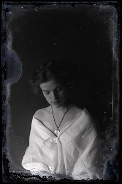 Portrait of an unidentified woman. She is wearing a necklace with a large pendant. 