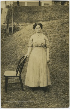 An unidentified woman is pictured in a yard with her hand placed on a chair. She is likely a relative to Walter Dix Lewis. 