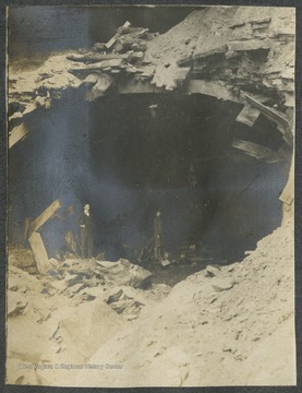 Two unidentified men stand at the entrance of the tunnel.This photograph is found in a scrapbook documenting the survey for the Baltimore and Ohio Railroad in West Virginia and surrounding states. 