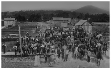 A mob returns to Parsons, W. Va. from the former seat of Tucker County, St. George.  The mob had taken records from the old courthouse by force.The view is from the corner of Main Street and Second Street, looking northeast down Second Street toward the Shavers Fork River and a treeline.  In the top right corner in the distance is a mountain called Turkey Knob.Ward Parsons, the leader of the mob, is pictured in the lower right on a black horse.