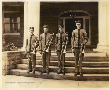Photograph of four Cadet Band members on the steps of Purinton House, which was then home to the university president.  Pictured are, left to right, Herbert Lynn McLaughlin, Edgar Frank Heiskell, O. D. Gill, and M. H. Thorn.