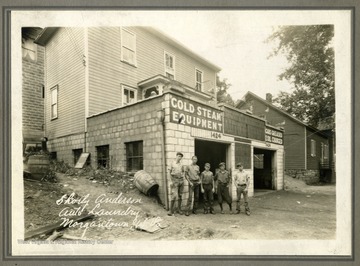A group of boys pose outside of Shorty Anderson's Auto Laundry. Text on back reads, "University Ave. Zackquill Morgan home on the right."