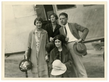 Text on the back reads, "Ready to go aboard the Sikorsky 'Sky Pullman' Yorktown on a sight-seeing flight over New York City. Misses Jean Roy, Noel Pridgeon and Katherine McCoy with a World reporter "top off" the summer session at Columbia in a modern manner." C. B. Allen is pictured with the students. 