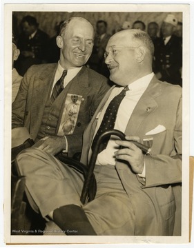 Text on the back reads, "Two men who in turn ruled the destinies of the  American Legion are pictured enjoying a pre-convention chat at Cleveland, where the legion opens its annual convention today, Sept. 21. At left is Hanford McNider, who was national commander in 1922, and at right, Louis A. Johnson, who held that high office in  1932. He hails from Clarksburg, W. Va., and is chairman of the Veterans' Committee in the Democratic Party."