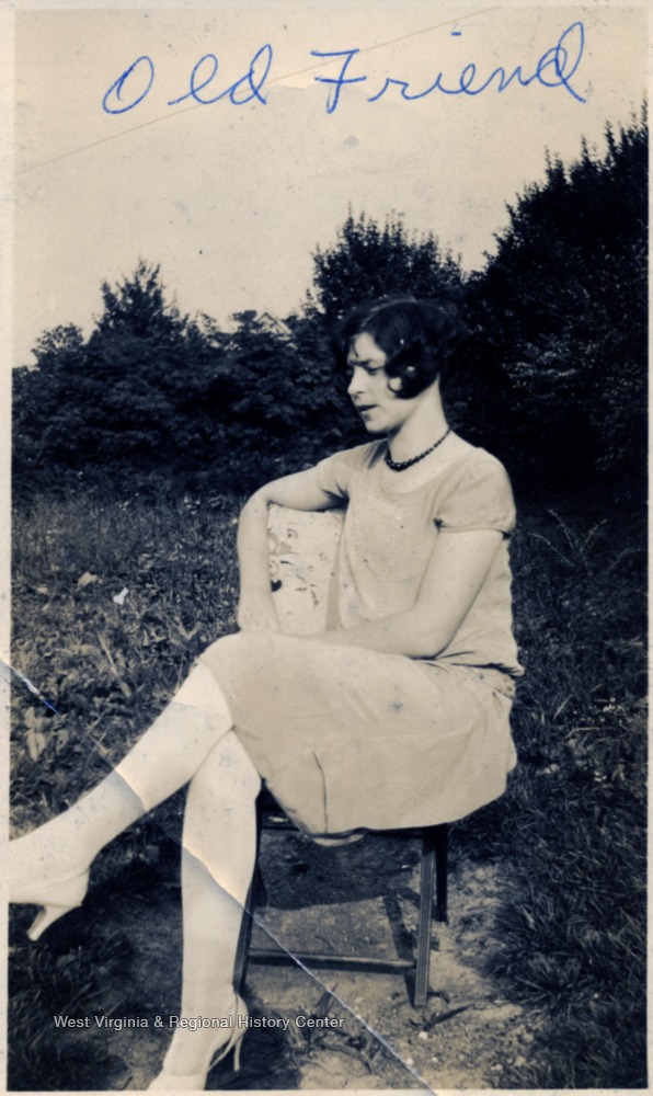 Woman seated in a chair outdoors.
