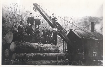 Logging crew posing on locomotive.